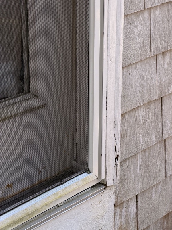 Canto de porta com trim rachado ao lado de shingle